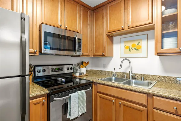 a kitchen with stainless steel appliances granite countertop a sink stove and microwave