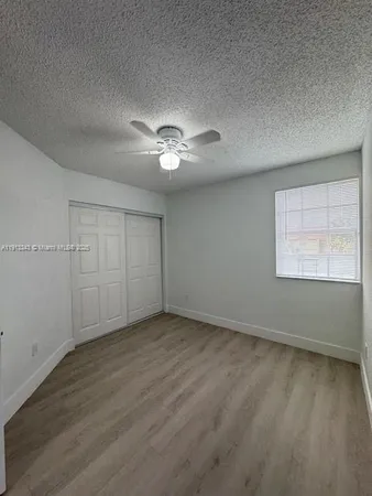 an empty room with fan and windows