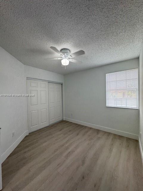 18344 Northwest 68th Avenue, Unit K Hialeah, FL 33015 - Photo 8 of 9 an empty room with fan and windows