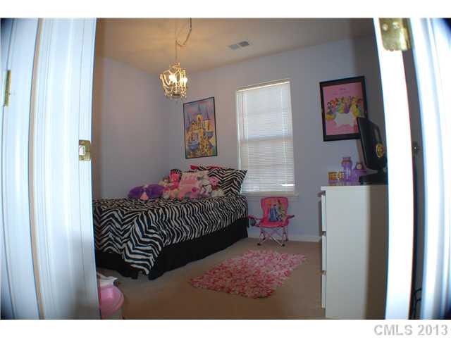 155 Mott Road Mooresville, NC 28115 - Photo 7 of 9 a bedroom with a bed and a chandelier