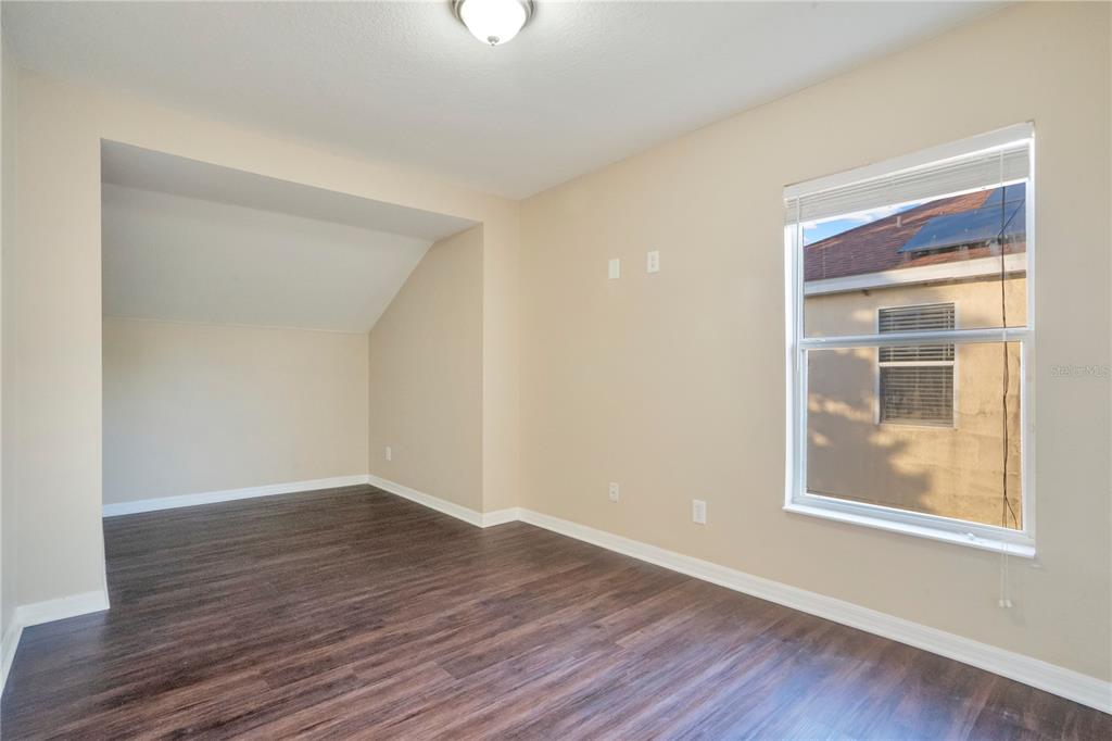 15031 Skip Jack Loop Lakewood Ranch, FL 34202 - Photo 19 of 27 a view of an empty room with wooden floor and a window