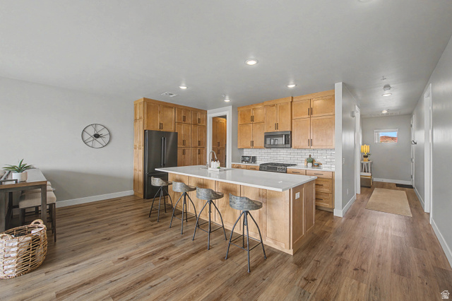 271 North Country Lane, Unit 12 St. George, UT 84770 - Photo 1 of 1 Kitchen with stainless steel appliances, dark wood-style flooring, a large island with sink, a breakfast bar area, and recessed lighting