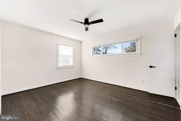 a view of a livingroom with wooden floor and a ceiling fan