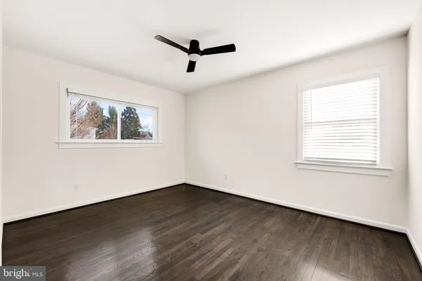 a view of a big room with wooden floor and windows