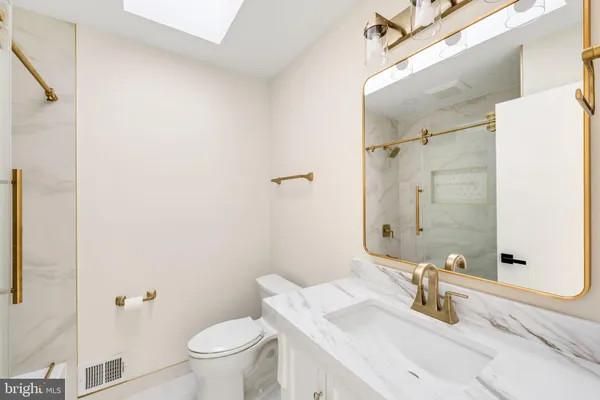 a bathroom with a sink a toilet and shower