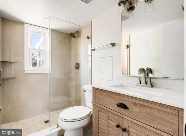 a bathroom with a granite countertop sink toilet and shower
