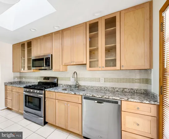 a kitchen with granite countertop cabinets stainless steel appliances and a sink