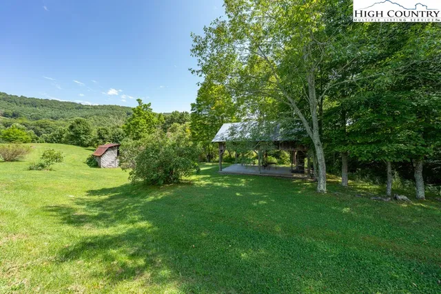 a view of a lush green outdoor space with a lake view