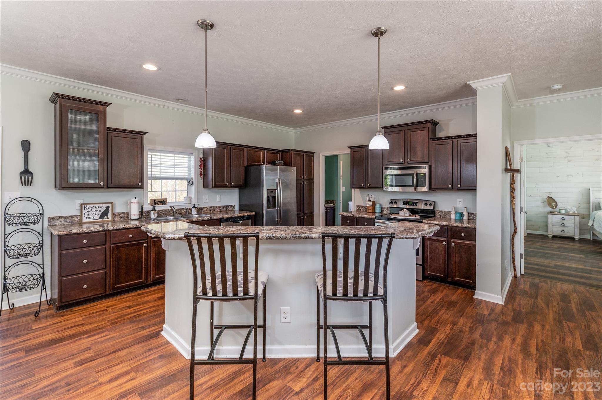 740 Renshaw Ford Road Woodleaf, NC 27054 - Photo 16 of 33 a kitchen with stainless steel appliances granite countertop wooden floors a stove a sink and a refrigerator