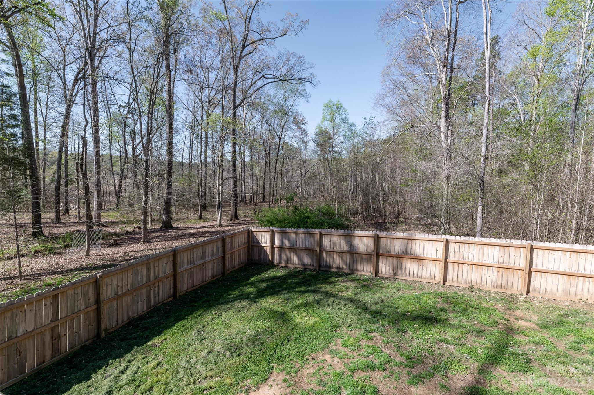 740 Renshaw Ford Road Woodleaf, NC 27054 - Photo 32 of 33 a view of a backyard with large trees and wooden fence
