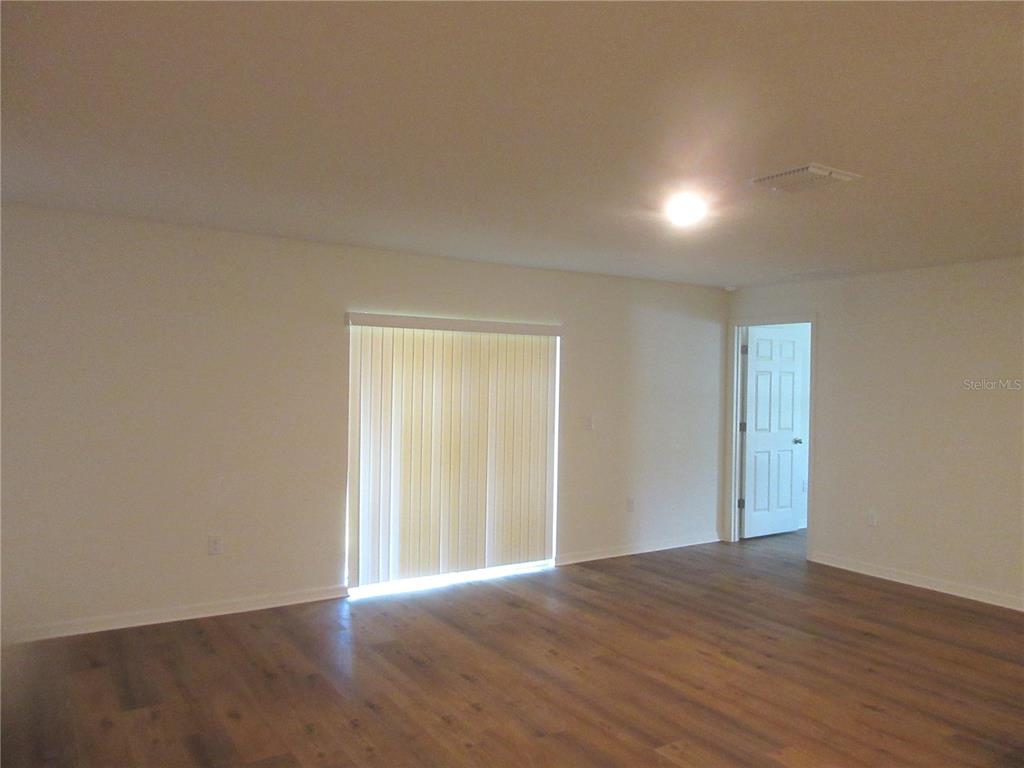 13130 Southwest 78th Circle Ocala, FL 34473 - Photo 5 of 14 an empty room with wooden floor and windows