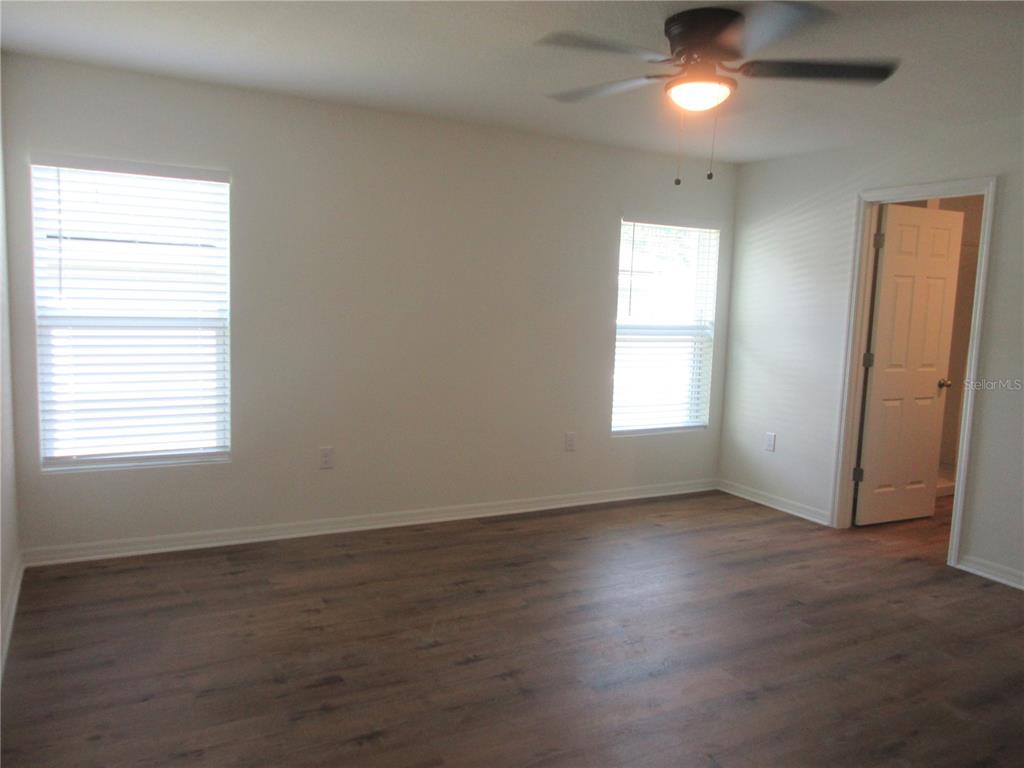13130 Southwest 78th Circle Ocala, FL 34473 - Photo 6 of 14 an empty room with wooden floor and windows