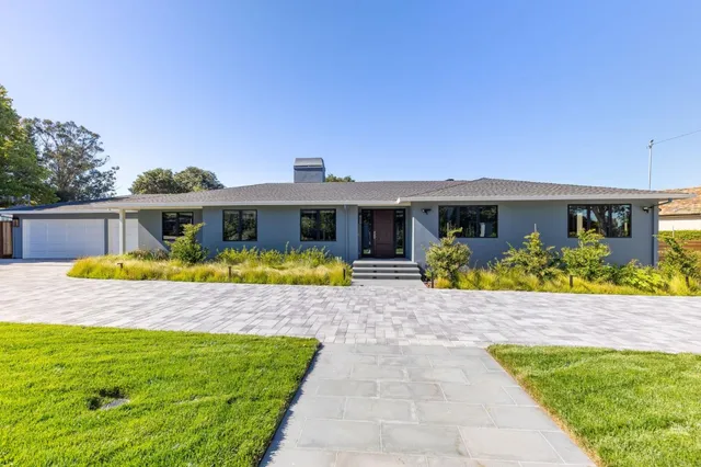 a kitchen with stainless steel appliances wooden floor and living room view