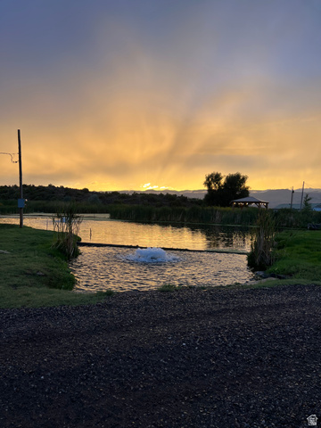 202 North Westhaven Road Richfield, UT 84701 - Photo 3 of 10 Pond with aerator feature, bordered by natural reeds and a grassy bank
