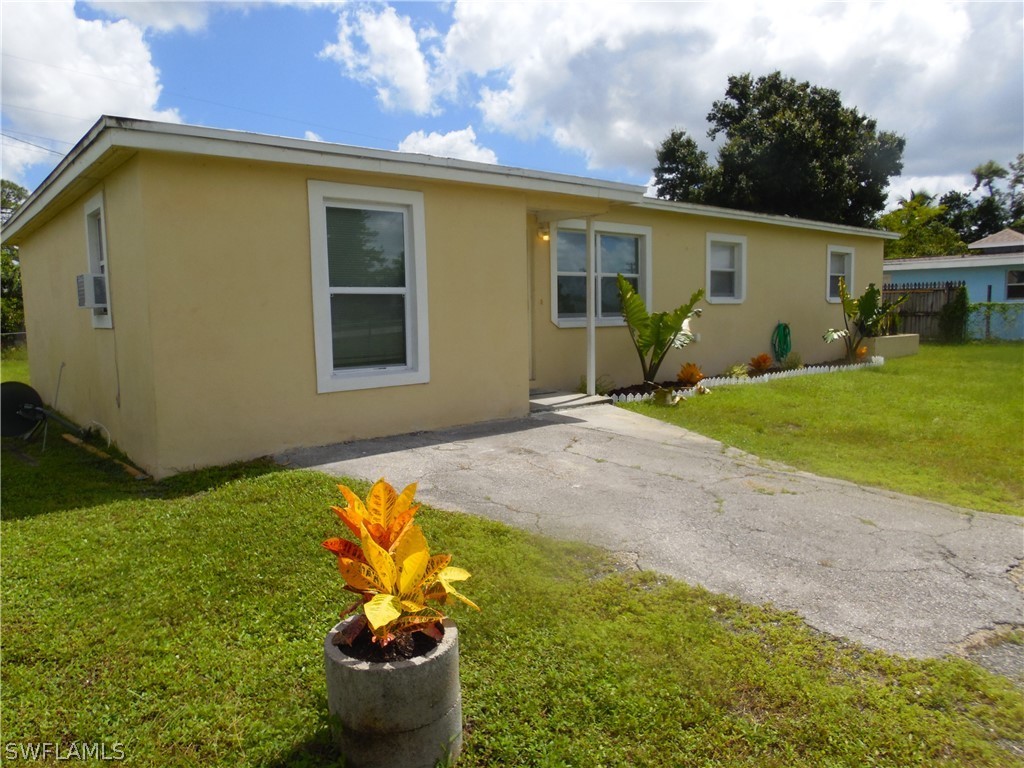 102 Alabama Road South Lehigh Acres, FL 33936 - Photo 1 of 24 a house view with a garden space