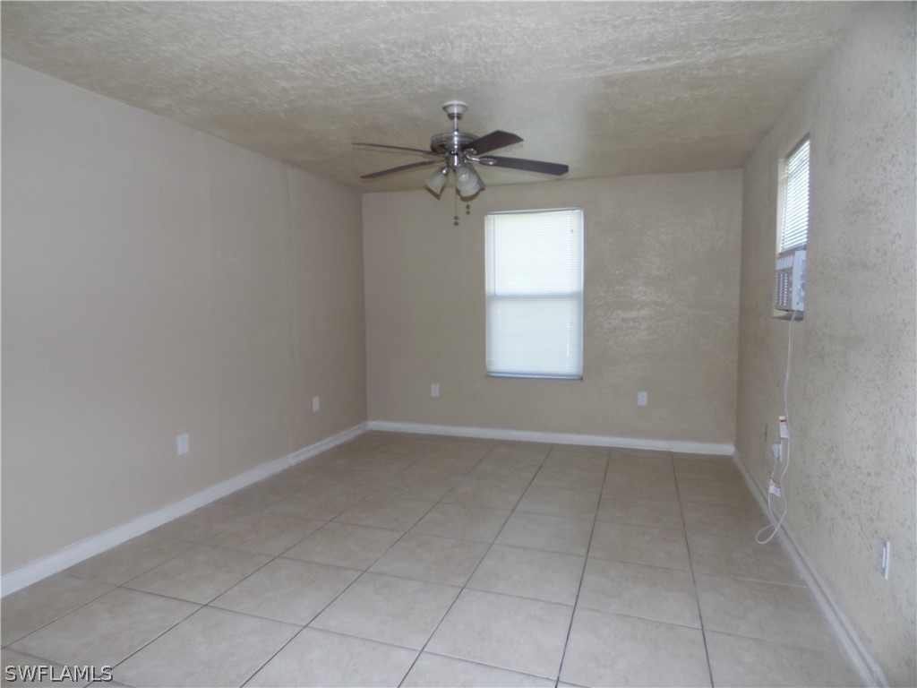 102 Alabama Road South Lehigh Acres, FL 33936 - Photo 11 of 24 an empty room with windows and fan