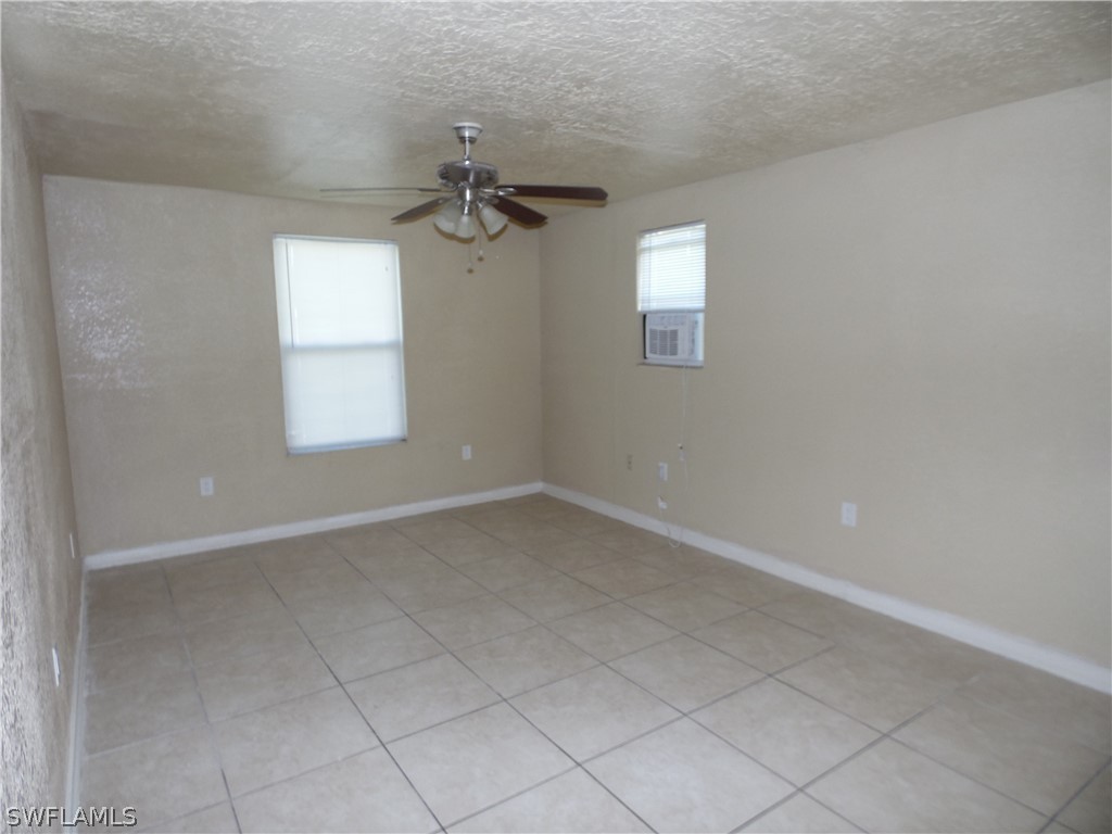 102 Alabama Road South Lehigh Acres, FL 33936 - Photo 12 of 24 an empty room with windows and fan