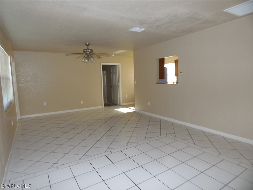 102 Alabama Road South Lehigh Acres, FL 33936 - Photo 5 of 24 an empty room with chandelier fan