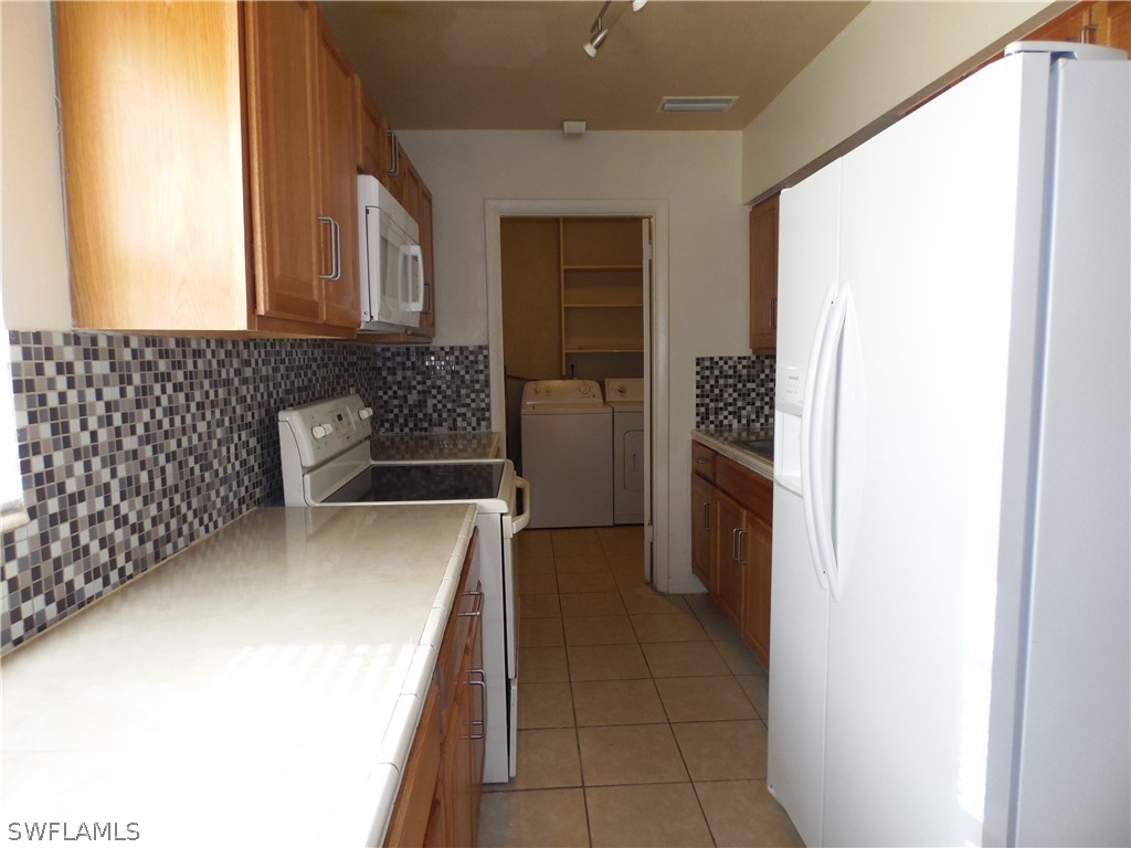 102 Alabama Road South Lehigh Acres, FL 33936 - Photo 7 of 24 a kitchen with a refrigerator and stove