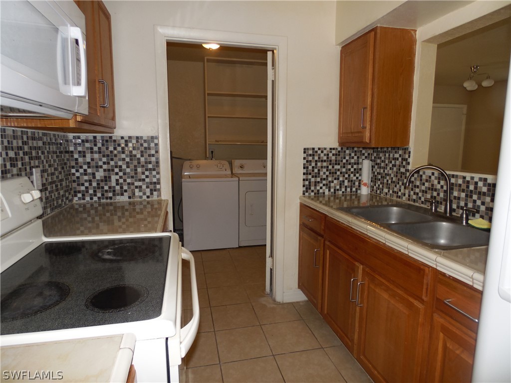 102 Alabama Road South Lehigh Acres, FL 33936 - Photo 8 of 24 a kitchen with a sink and refrigerator