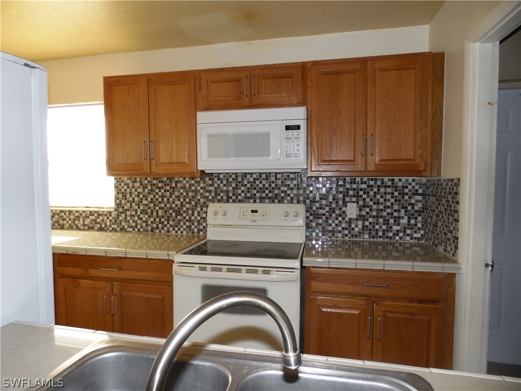 102 Alabama Road South Lehigh Acres, FL 33936 - Photo 9 of 24 a utility room with dryer and washer