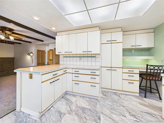 a living room with furniture a fireplace and a large window