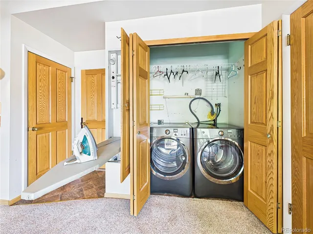 a living room with a table chairs and a kitchen view
