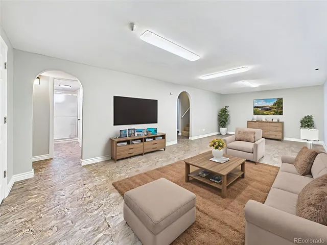 a living room with furniture a rug and a lamp