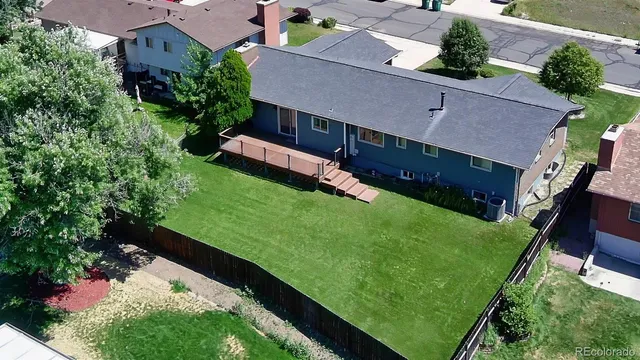 a view of a patio with table and chairs with wooden floor and fence