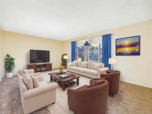 a living room with furniture a flat screen tv and a large window