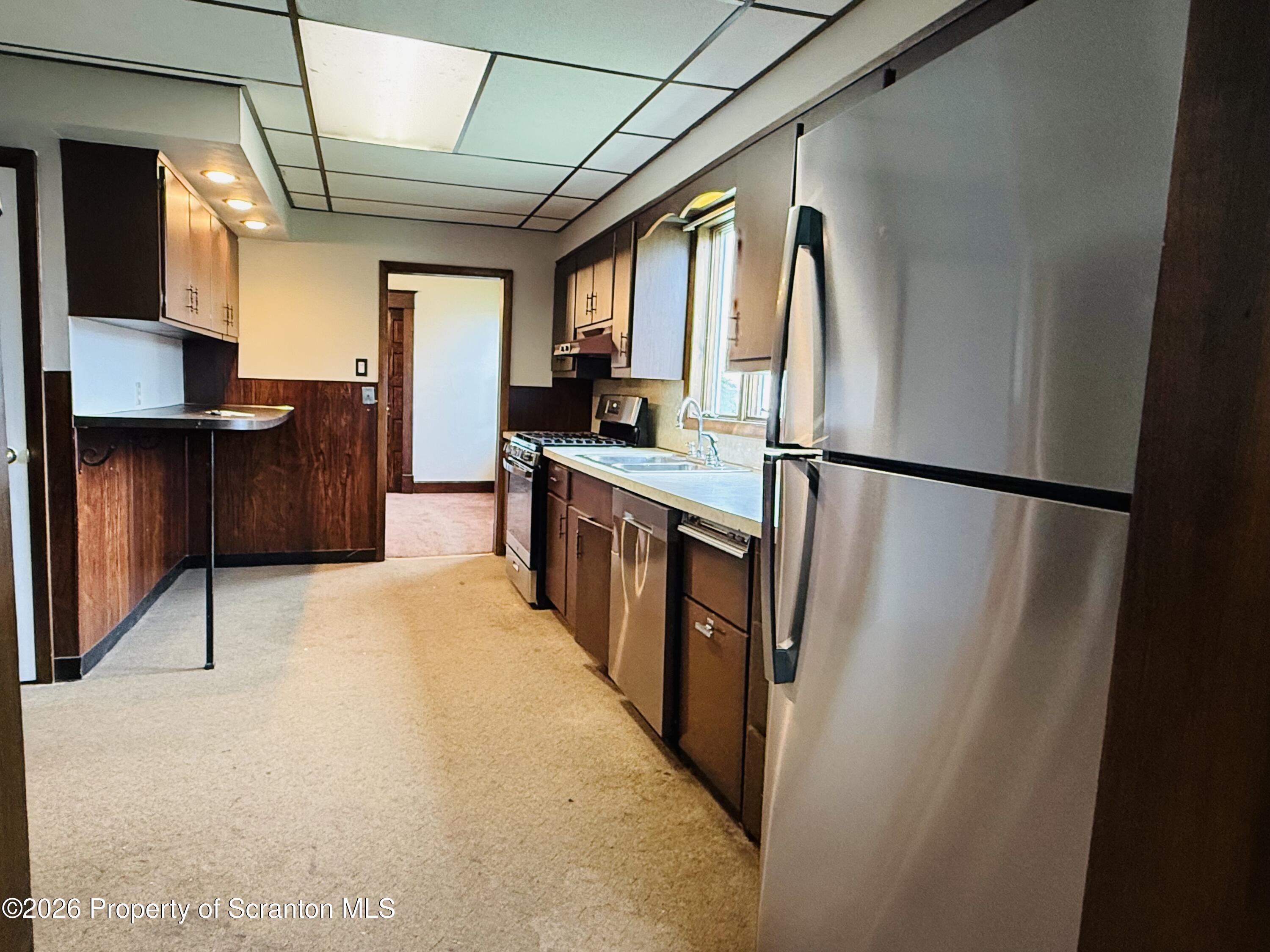 1922 Lafayette Street Scranton, PA 18504 - Photo 6 of 17 a kitchen with stainless steel appliances granite countertop a refrigerator a sink dishwasher a stove and a dining table with wooden floor