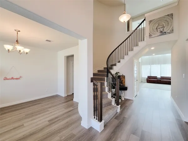 a view of a hallway with wooden floor and staircase