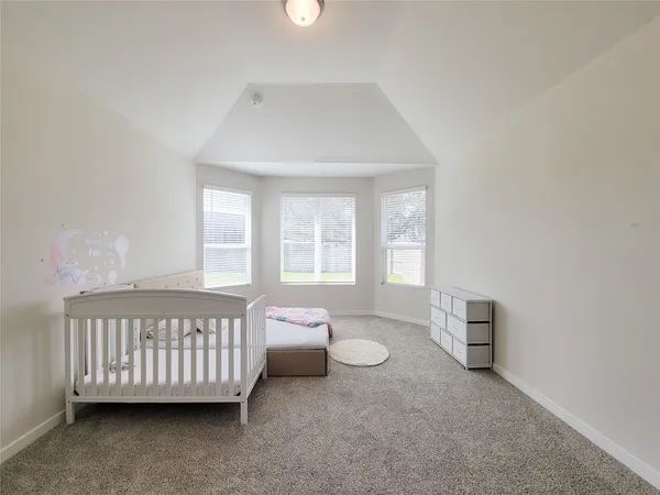 a spacious bedroom with a bed and a window