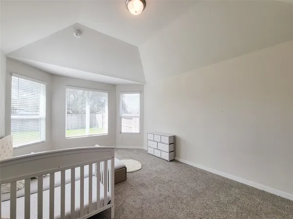 a spacious bedroom with a bed and a window