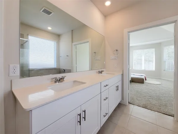 a spacious bathroom with a double vanity sink and mirror