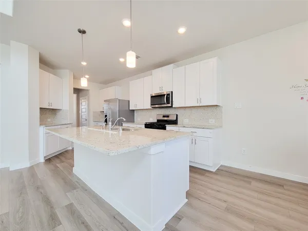 a kitchen with kitchen island white cabinets and stainless steel appliances