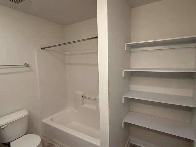 a bathroom with a toilet and a shower