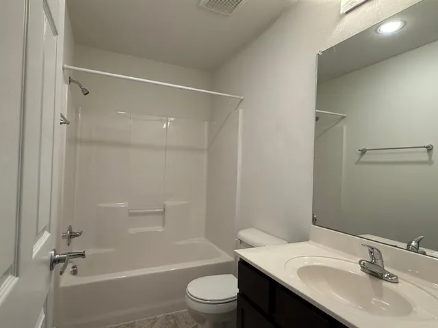 a bathroom with a sink toilet vanity and shower