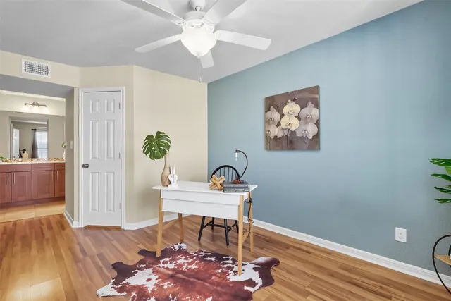 a workspace with wooden floor and a chandelier fan