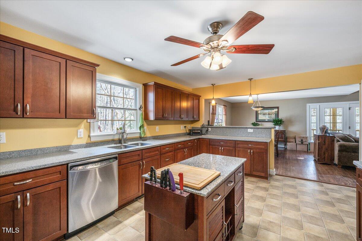 348 Raymond Tharrington Road Louisburg, NC 27549 - Photo 26 of 47 a kitchen with stainless steel appliances granite countertop a sink a stove and a wooden cabinets