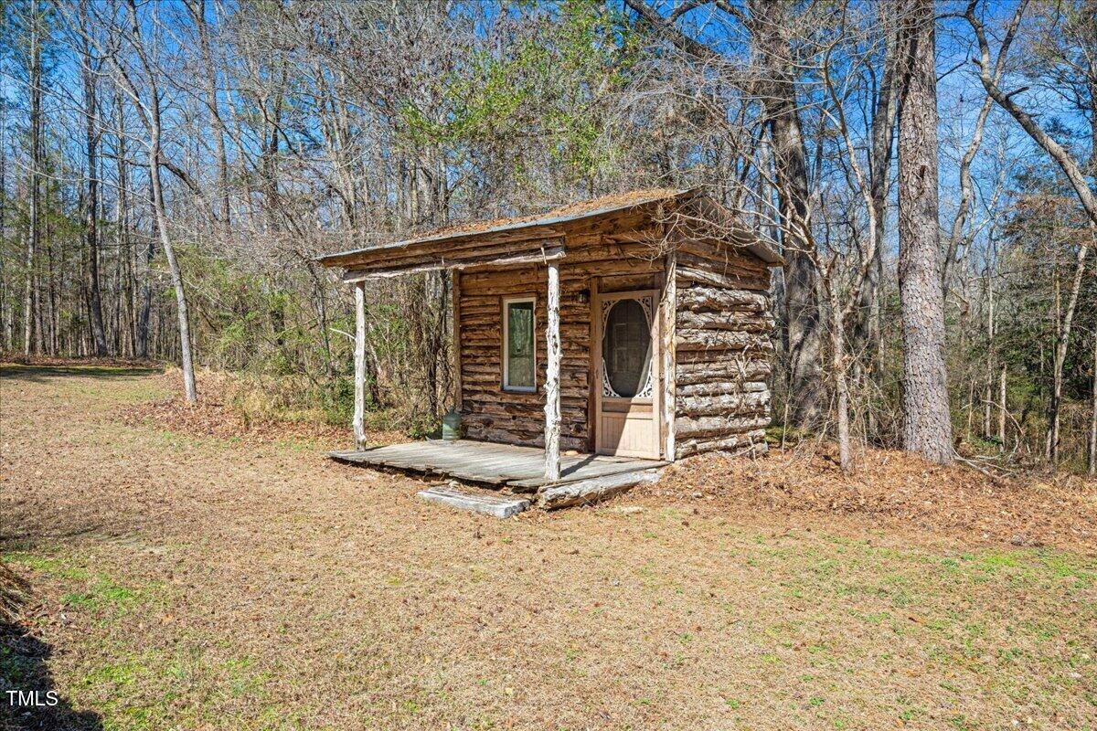 348 Raymond Tharrington Road Louisburg, NC 27549 - Photo 37 of 47 a view of a wooden house with large trees