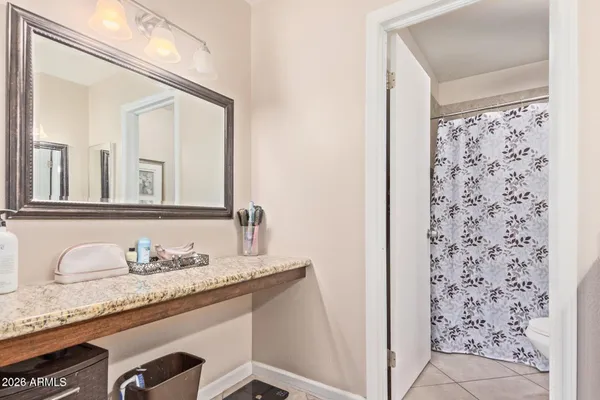 a bathroom with a granite countertop sink a mirror and shower