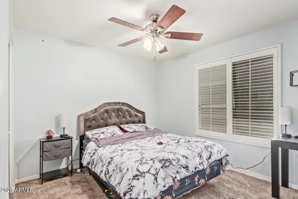 a bedroom with a bed and a large window