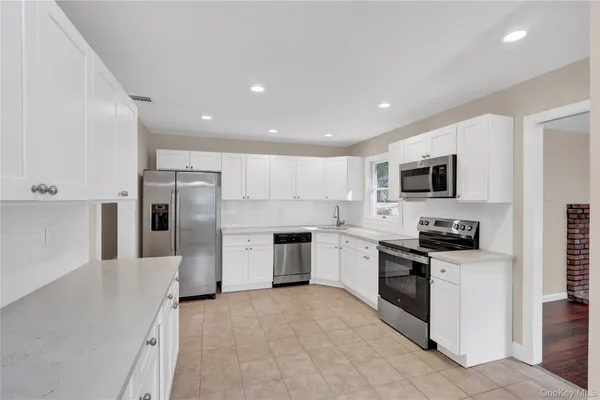 a kitchen with stainless steel appliances granite countertop a refrigerator and a stove top oven
