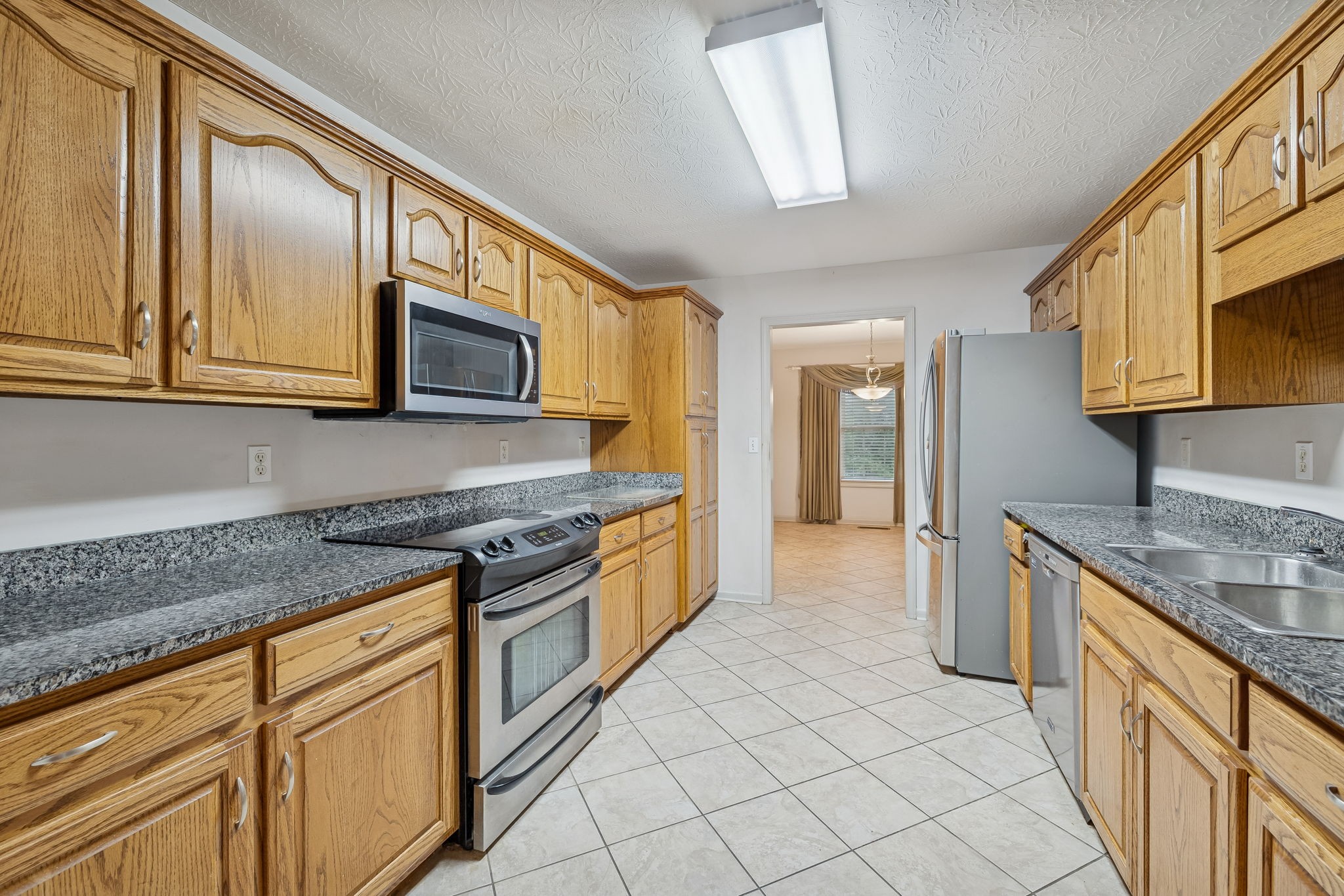 788 Long Creek Road Lafayette, TN 37083 - Photo 12 of 32 a kitchen with stainless steel appliances granite countertop a stove a sink and a microwave