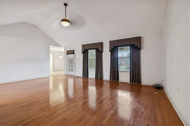 a view of a room with a chandelier fan and windows