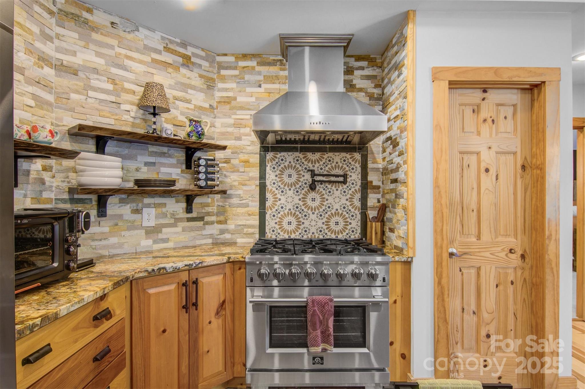 5690 Anchor Drive Granite Falls, NC 28630 - Photo 14 of 48 a kitchen with stainless steel appliances granite countertop a stove and a wooden cabinets
