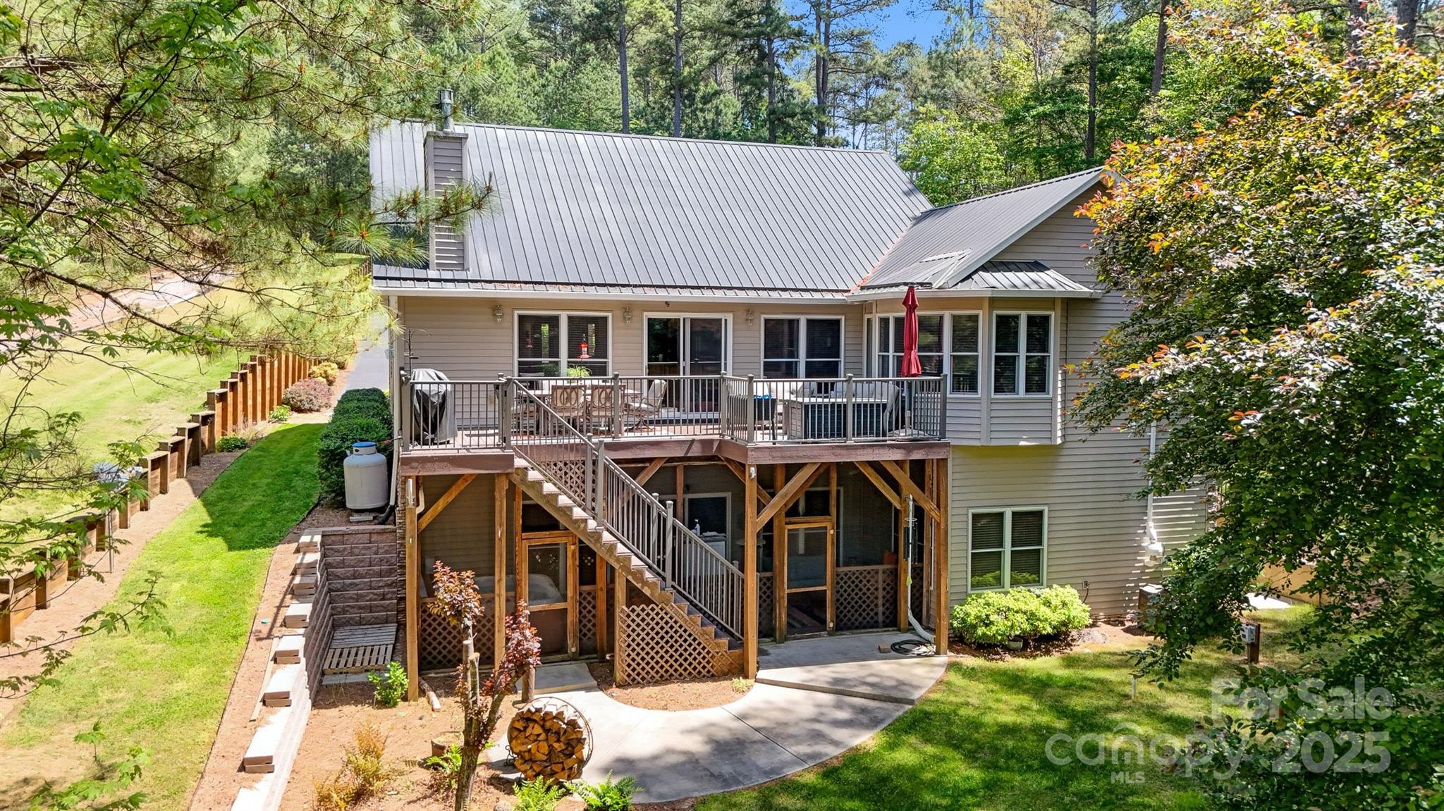 5690 Anchor Drive Granite Falls, NC 28630 - Photo 33 of 48 a view of a white house with large windows and a table and chairs