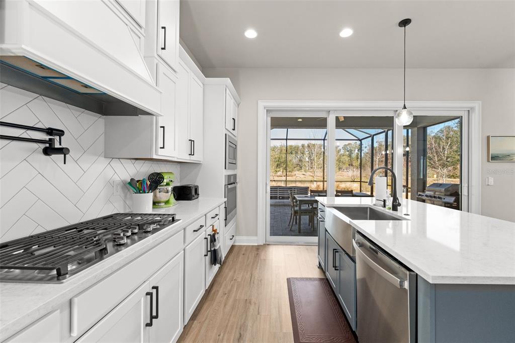 10778 Southwest 34th Road Gainesville, FL 32608 - Photo 13 of 62 a kitchen with stainless steel appliances a sink a stove top oven a counter space and cabinets