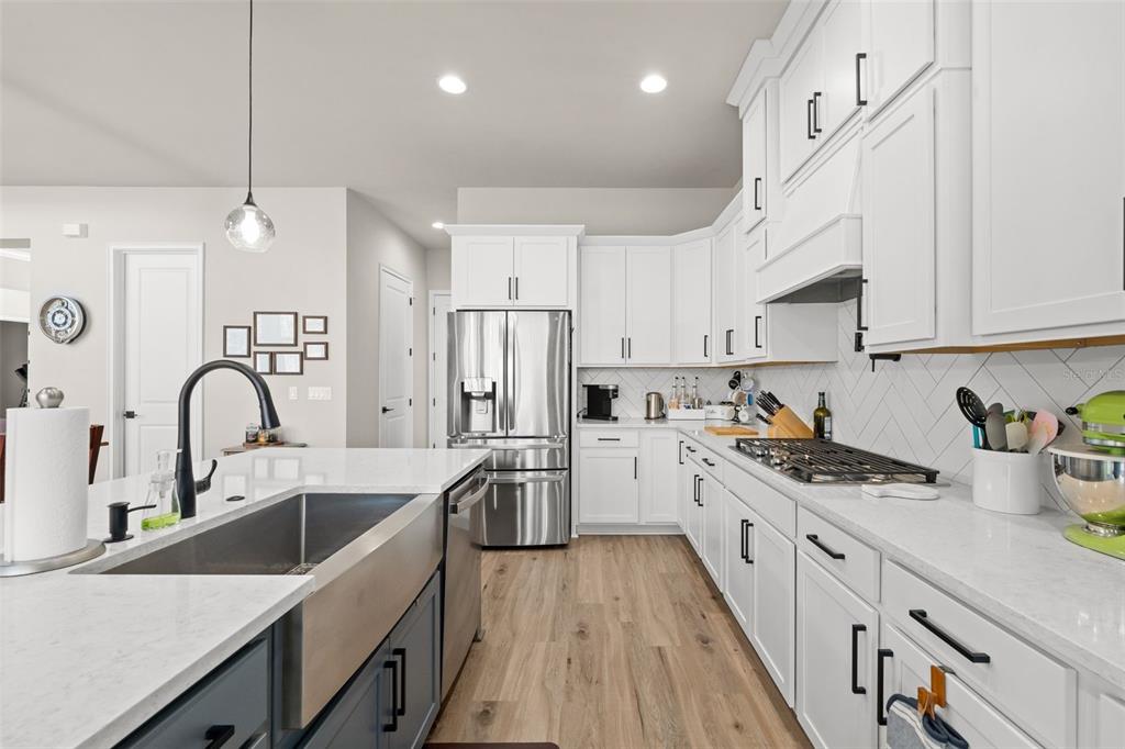 10778 Southwest 34th Road Gainesville, FL 32608 - Photo 14 of 62 a kitchen with stainless steel appliances a sink a stove top oven a counter space and cabinets